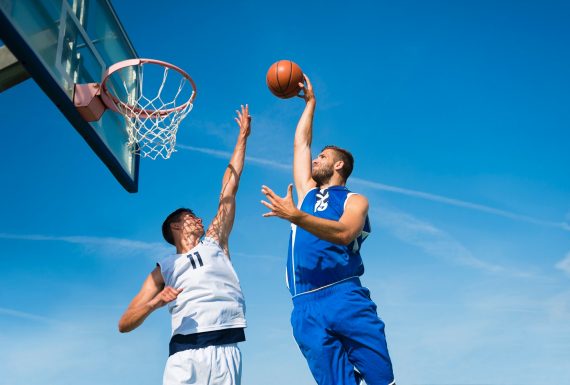 502034445 Low angle view of young basketbal players in the scoring action